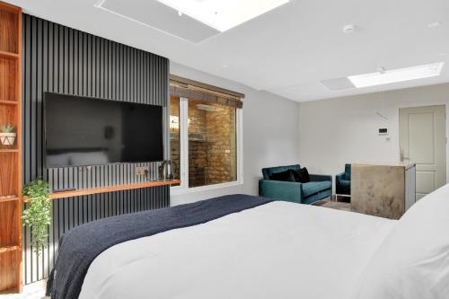 a bedroom with a large bed and a flat screen tv at Skyline Studios in London