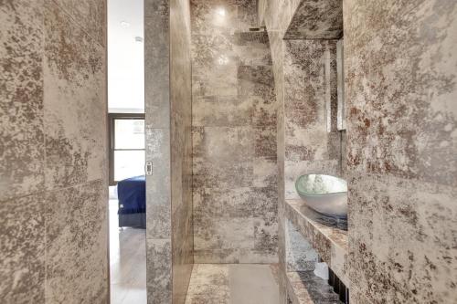 a bathroom with a stone wall with a bowl on a counter at Skyline Studios in London