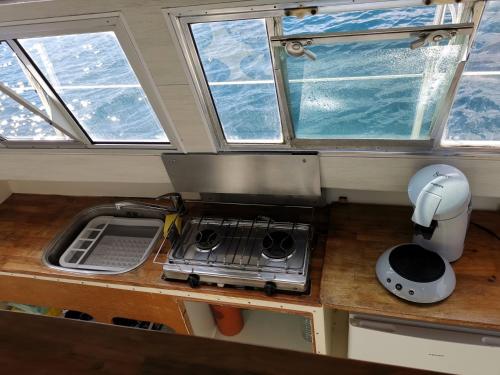 une cuisine avec quatre fenêtres et un comptoir avec une cuisinière dans l'établissement Nuit insolite - Bateau Logement Catamaran AVENTURE - Dormez sur l'eau, à Agay