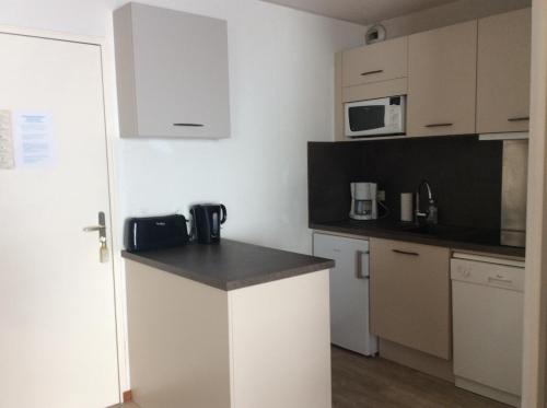 une petite cuisine avec un comptoir et un micro-ondes dans l'établissement Le Corbier, bel appartement bien exposé, à Villarembert