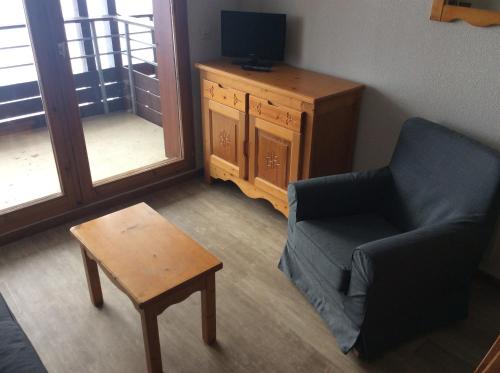 un salon avec une chaise et une table dans l'établissement Le Corbier, bel appartement bien exposé, à Villarembert