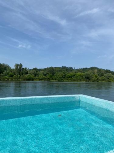 a swimming pool on the side of a body of water at Banja na Drini - Lux vikendice na obali reke in Banja Koviljača