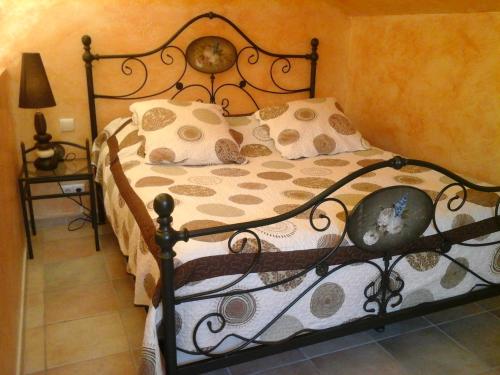 1 dormitorio con cama con marco de metal y almohadas en Mas des Lys, en Roquebrune-sur-Argens