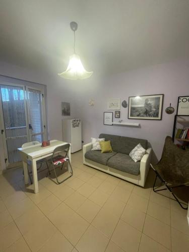 sala de estar con sofá y mesa en Appartamento vista mare en Copanello