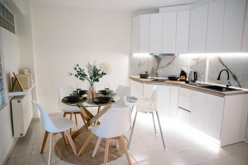 een keuken met een tafel en stoelen in een kamer bij La Martina Glam Residence - 15 Airport Macedonia in Trílofon