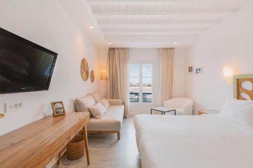 a hotel room with a bed and a couch and a tv at San Antonio Summerland in Mýkonos City