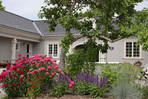 una casa bianca con dei fiori davanti di Wergelandshaugen a Eidsvoll