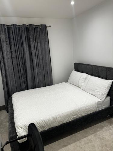 Bett in einem Zimmer mit einem schwarzen Vorhang in der Unterkunft Luxury Ensuite Double bedroom in Poole