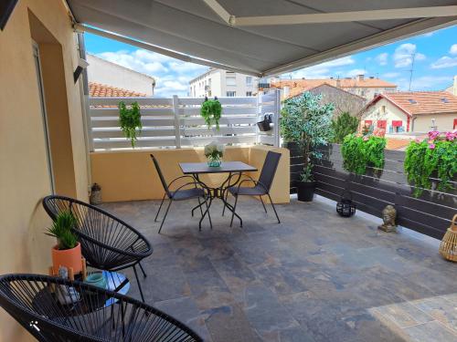 a patio with chairs and a table on a balcony at L''indochine in Perpignan