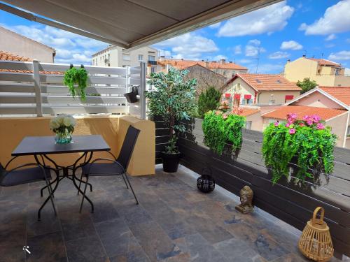 a patio with a table and chairs on a balcony at L''indochine in Perpignan