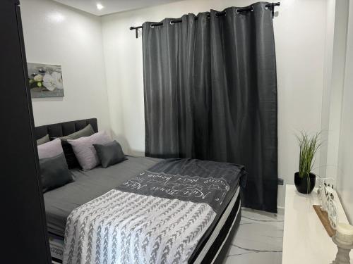 - une chambre avec un lit et un rideau noir dans l'établissement Maha Beach Cabo Negro Duplex, à Cabo Negro