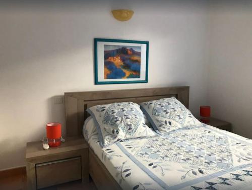 un lit dans une chambre avec un tableau sur le mur dans l'établissement MINI-VILLA individuelle de 40 m2 (3 ETOILES), à Porto-Vecchio