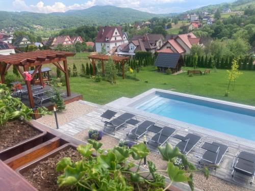 een zwembad in een tuin met stoelen en een huis bij Apartamenty Black Lion in Pcim