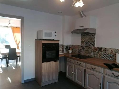 a kitchen with a microwave and a stove top oven at Maison conviviale à Farschviller in Farschviller
