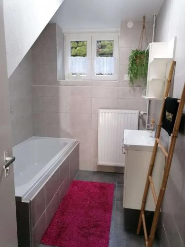 une salle de bain avec une baignoire et un lavabo dans l'établissement Maison conviviale à Farschviller, à Farschviller