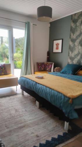 une chambre avec un grand lit et une fenêtre dans l'établissement la maison de Lison, au Château-dʼOléron