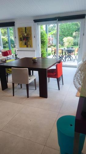une salle à manger avec une table et des chaises en bois dans l'établissement la maison de Lison, au Château-dʼOléron