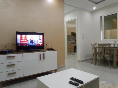 a living room with a flat screen tv on a cabinet at Ben arous one in Ben Arous