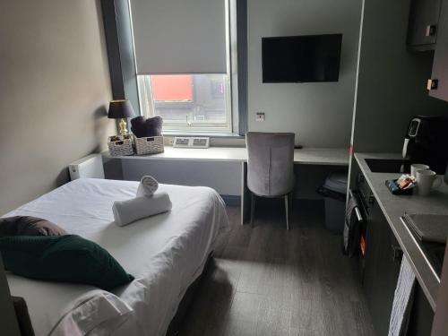 Pokój hotelowy z łóżkiem, biurkiem i oknem w obiekcie Tren-D Luxe Studio Apartment Room 3 - Contractors, Relocators, Profesionals, NHS Staff Welcome w mieście Sunderland