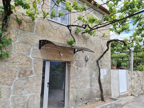 a stone house with a door and a window at Casa Maria da Eira in Arcos de Valdevez
