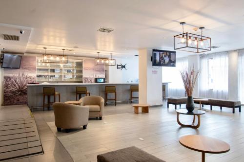 un hall avec des chaises et un bar dans un bâtiment dans l'établissement Hotel Plaza Génova Centro, à Guadalajara
