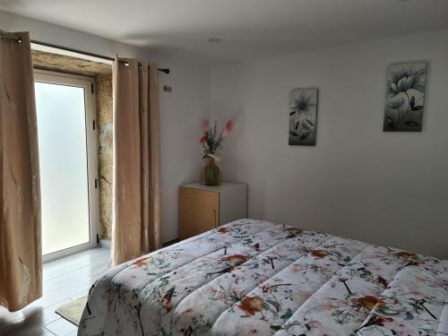 a bedroom with a bed and a window at Casa Maria da Eira in Arcos de Valdevez
