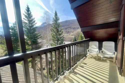 a balcony with two chairs and a view of the mountains at Ski nest with large balcony in La Salle Les Alpes