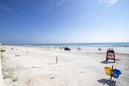 a beach with a bunch of people in the water at SeaBliss, oceanfront 1st floor cozy condo in Daytona Beach