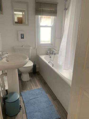 a bathroom with a sink and a tub and a toilet at Cute 1 bed flat in Southwold in Southwold