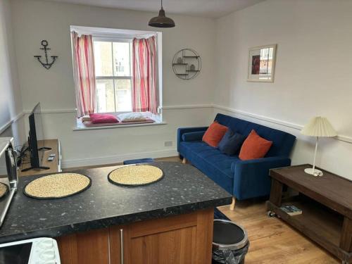 a living room with a blue couch and a table at Cute 1 bed flat in Southwold in Southwold
