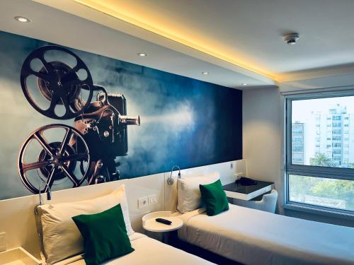 una camera da letto con un dipinto di una macchina fotografica sul muro di ibis Styles Montevideo Biarritz a Montevideo