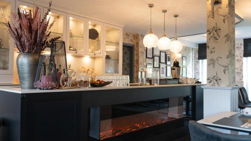 a living room with a fireplace in a kitchen at Parkhotel Cloppenburg in Cloppenburg