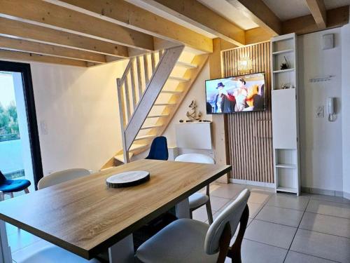 une salle à manger avec une table et des chaises en bois dans l'établissement Appartement cosy à Royan, à Royan