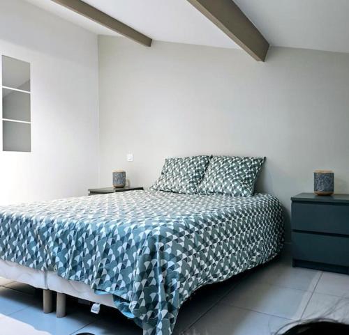 une chambre avec un lit avec un couvre-lit bleu et blanc dans l'établissement Appartement cosy à Royan, à Royan