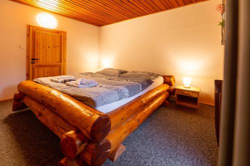 a bedroom with a bed made out of a log at Wellness Hotel Koliba in Komorní Lhotka
