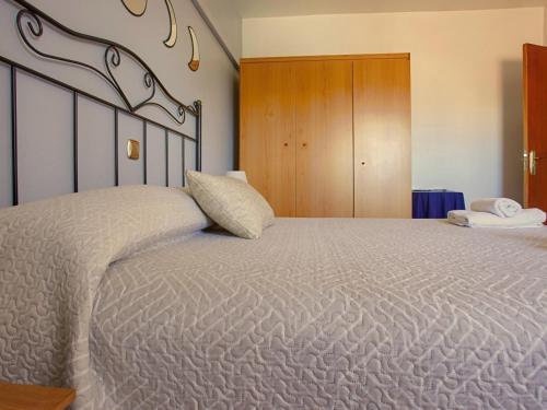 a bedroom with a large bed and a wooden cabinet at Casa Rural Los Mayorales II Apartamento in La Garrovilla