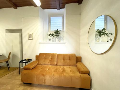a brown couch in a room with a mirror at Green Bridge Studio in Vilnius