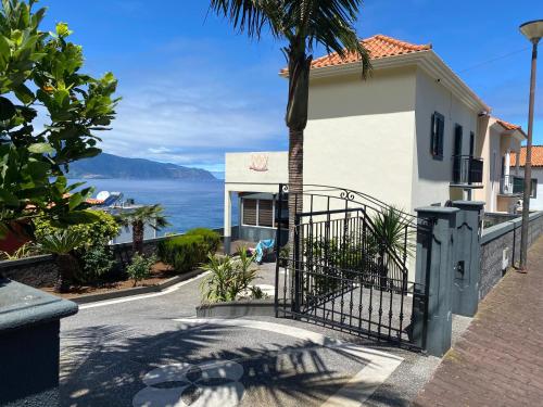 a gate to a house with a palm tree at The Vista House in Ponta Delgada