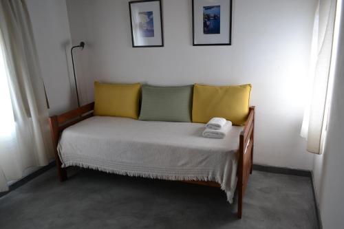 a bed with yellow and green pillows in a room at La Balconada by DOT Boutique in Villa Pehuenia