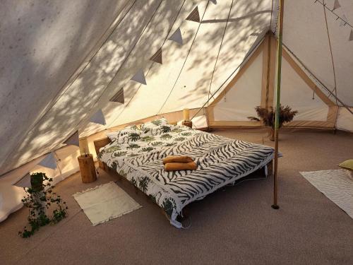 łóżko w namiocie w pokoju w obiekcie Glempings Bērzciema Lagūna w mieście Bērzciems