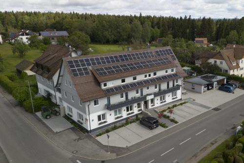 una gran casa blanca con paneles solares en el techo en Alter Hirsch, en Pfalzgrafenweiler