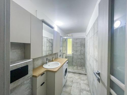 a bathroom with a sink and a washing machine at National Arena Mega Mall Mirina Studio in Bucharest