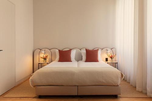 a bedroom with a large bed with red pillows at Vandoma in Porto