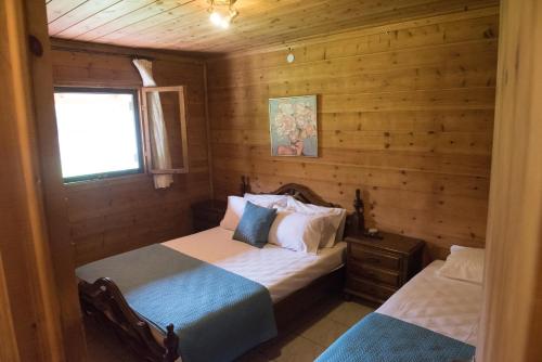 a bedroom with two beds in a log cabin at Garden Villa in Stavros
