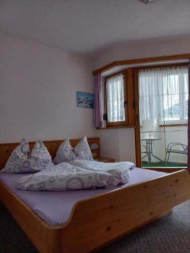 a bedroom with a large bed with a wooden frame at Ferienwohnung Lechthaler Andrea in Wenns