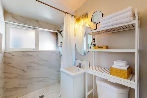La salle de bains blanche est pourvue d'un lavabo et d'une douche. dans l'établissement NEW Beautiful San Diego Mid-Century Treehouse, à Spring Valley