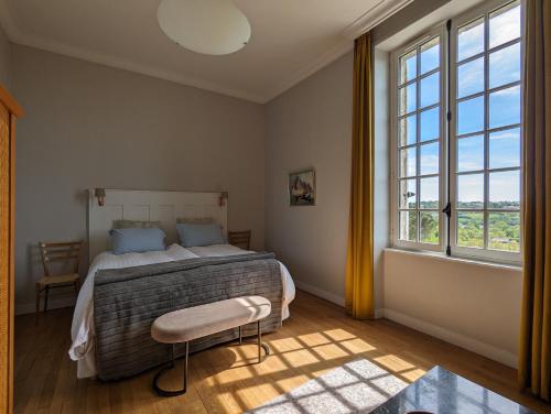 um quarto com uma cama e uma grande janela em Château Haute Roche em Oudon