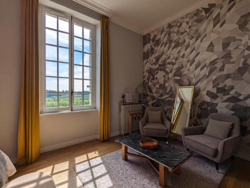 sala de estar con 2 sillas y mesa en Château Haute Roche en Oudon