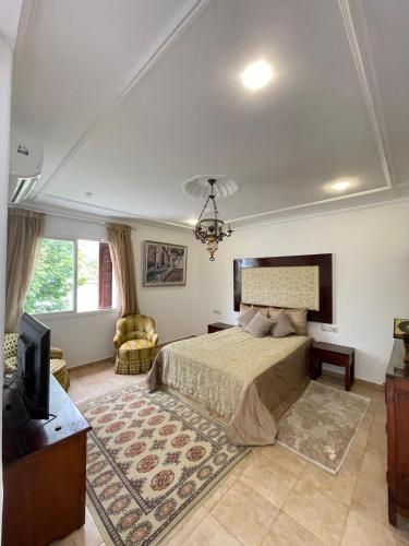 a bedroom with a bed and a tv in it at Villa 3 chambres piscine marinasmir in Tétouan