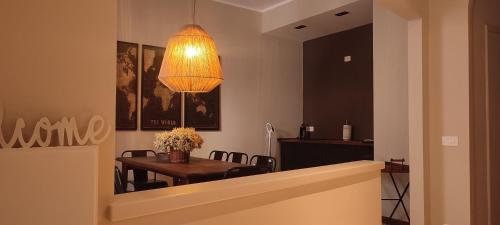 a dining room with a table and a chandelier at Rota's House III in Bergamo